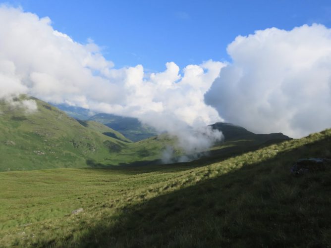 blue sky and low clouds over the hill