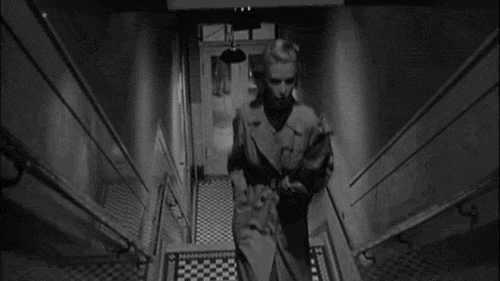 animated gif from black and white film reversed so woman appears to walk down the stairs