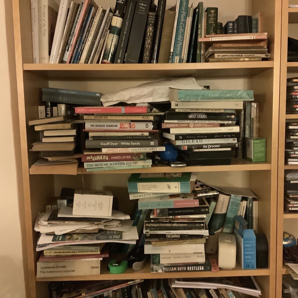 Lots of books untidily arranged on bookshelves