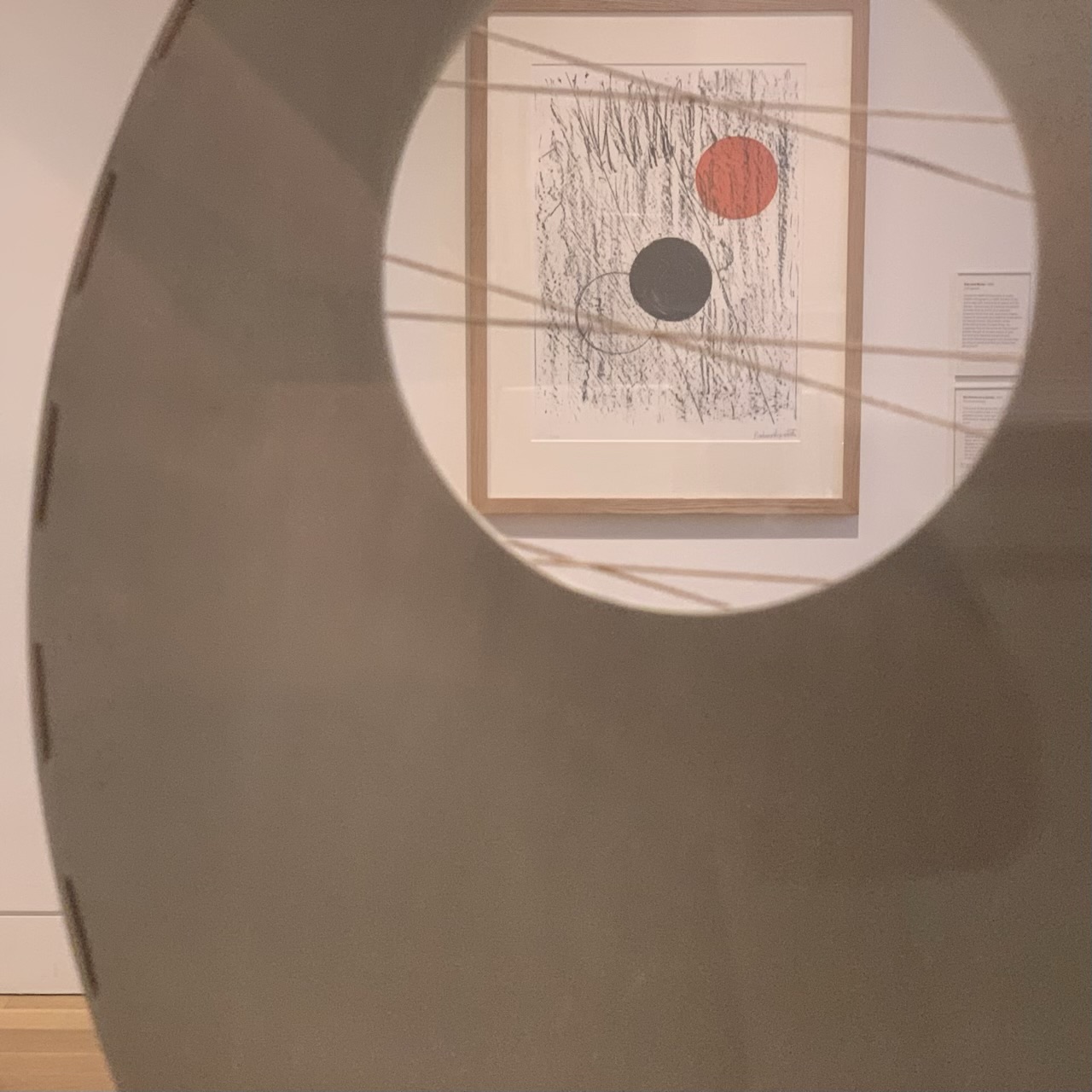Looking through a circular hole in a Barbara Hepworth sculpture and a picture by the same artist.