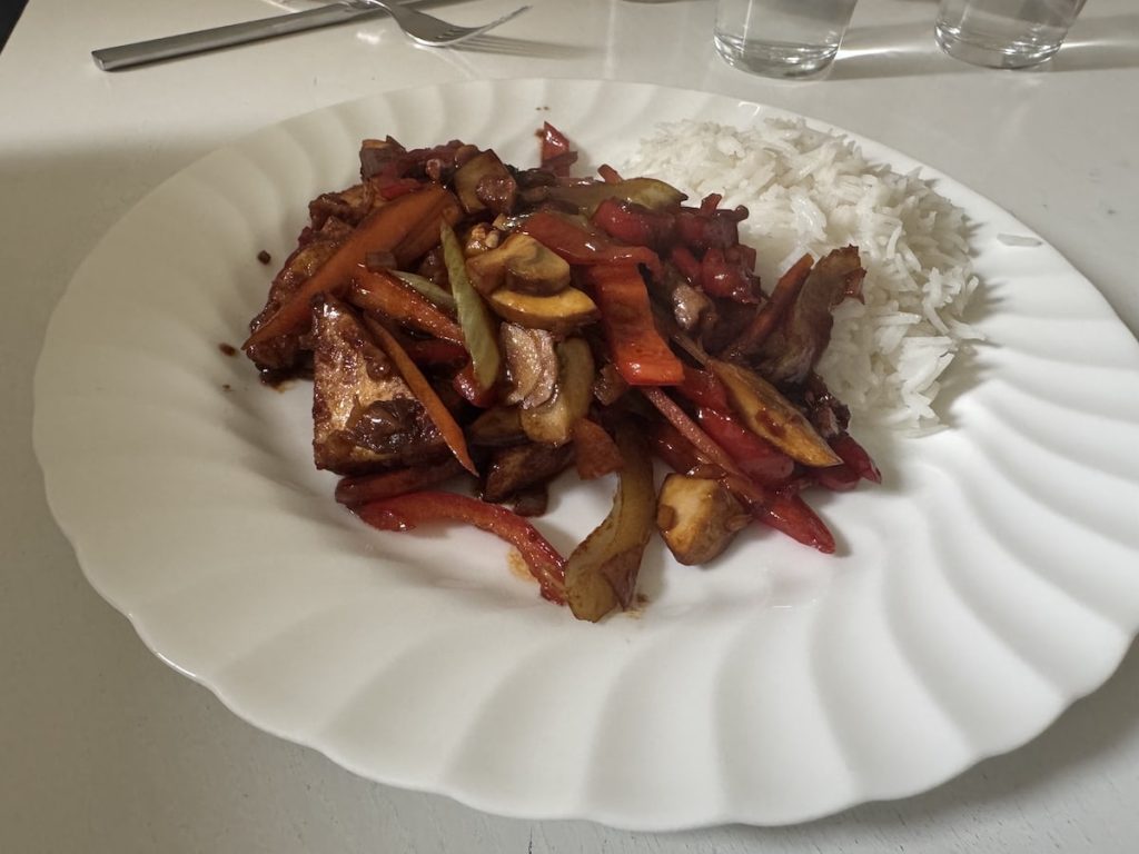 Plate of stir-fried vegetables and tofu with white rice.
